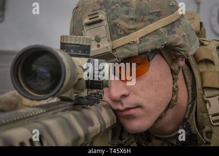 Océan Pacifique (fév. 20, 2019) U.S. Marine Corps Cpl. Henry l'aneth, le scout sniper avec des armes, de l'entreprise Équipe de débarquement du bataillon du 3e Bataillon, 5e Régiment de Marines, 11e Marine Expeditionary Unit (MEU), sites de derrière un spécial de calibre 50 avec lunette de visée des applications à bord de la classe San Antonio-dock transport amphibie USS John P. Murtha (LPD 26). Les Marines et les marins du 11e MEU mènent des opérations de routine dans le cadre du groupe amphibie Boxer dans l'océan Pacifique. Banque D'Images