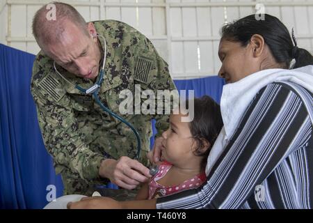 VENCEDOR, Brésil (fév. 27, 2019) Le Cmdr. Edmund Milder examine un jeune patient lors d'une clinique médicale à Vencedor, Brésil, le 27 février. La visite marque la neuvième et dernière étape de la mission d'un mois par quatre médecins de la Marine américaine et leurs homologues de la marine brésilienne embarquée à bord de navire-hôpital de la marine brésilienne Carlos Chagas NAsH (U 19) pour échanger de l'expertise médicale et d'apporter des soins médicaux aux communautés isolées le long de la rivière Amazone. Banque D'Images