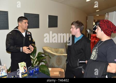 SEGUIN, Texas (1 mars 2019) Conseiller de la Marine 1ère classe Jose Zouain (gauche) de Lake Mary, en Floride, affectés à des activités de recrutement pour la Marine Station (NRS) San Marcos, parle avec les participants sur les possibilités en Amérique du Nord au cours de la Marine U.S. Navy Band concert organisé à l'Auditorium de Jackson sur le campus de Texas Lutheran University. Après avoir obtenu son diplôme de Lake Mary High School, Zouain a rejoint en 2005, la marine du Nord de devenir un recruteur en 2011. La U.S. Navy Band effectuée dans 10 états au cours de son 23-ville, à 5 000 milles de tour, reliant les collectivités de tout le pays pour leur marine. La tour sert le public avec ent Banque D'Images