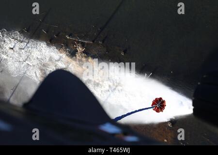 Un seau d'eau libère sa charge d'eau sur un lac pendant un vol de vérification entre la Garde nationale de Washington d'aviateurs et l'US Forest Service. Les pilotes et leurs chefs d'équipage sur l'eau former chaque année pour préparer les opérations de godet terre sauvage pour la saison des feux de forêt. Banque D'Images