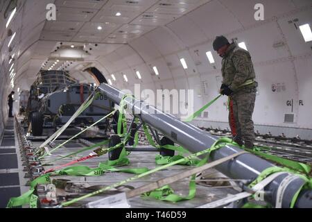 California Air National Guardsman Tech. Le Sgt. Mike Hewitt à sangles d'une barre de remorquage dans l'intérieur d'un Boeing 747 sous contrat à la 171e Escadre de ravitaillement en vol, d'un New York Air National Guard, près de Pittsburgh en Pennsylvanie, le 11 mars 2019. Banque D'Images