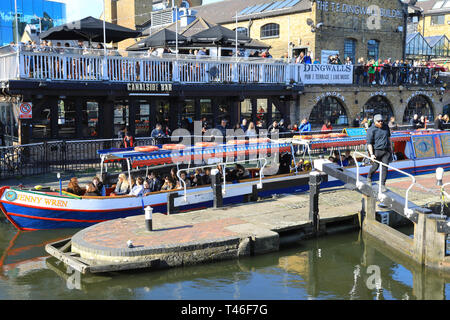 Barge avec les touristes de passage entre Camden Lock sur le Regents Canal, au soleil du printemps, dans le nord de Londres, UK Banque D'Images