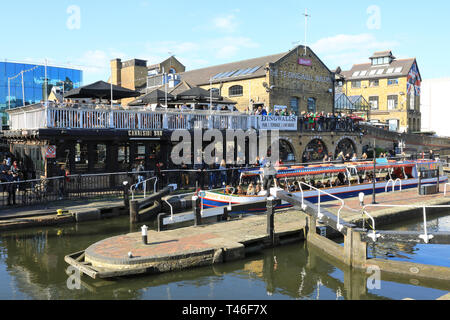 Barge avec les touristes de passage entre Camden Lock sur le Regents Canal, au soleil du printemps, dans le nord de Londres, UK Banque D'Images