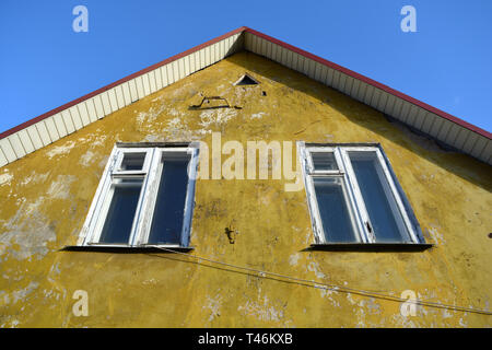 Vieille maison mur jaune avec deux fenêtre en bois Banque D'Images
