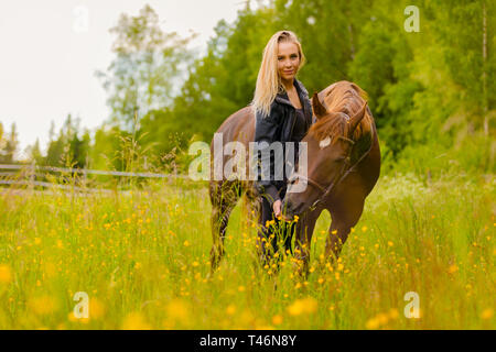 Portrait de femme nourrir son cheval arabe avec des collations dans le domaine Banque D'Images