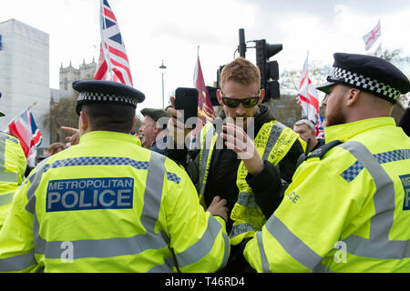 Un manifestant vu holding a mobile phone devant des officiers de police lors de la manifestation. Les manifestants se sont réunis à la place du Parlement et ont défilé à différents endroits, y compris le pont de Westminster, Downing Street, Trafalgar Square de bloquer les rues et de faire face à la police. La demande des manifestants par le gouvernement et les politiciens à quitter l'Union européenne sans un accord et livrer ce qui a été promis. Banque D'Images