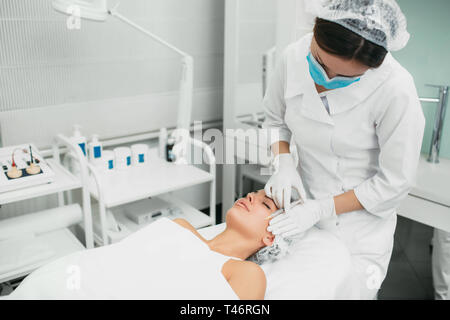 Coiffeur making injection contre les rides dans le visage de femme Banque D'Images