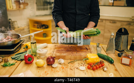 Personne mâle cuire la viande avec les légumes dans une casserole Banque D'Images