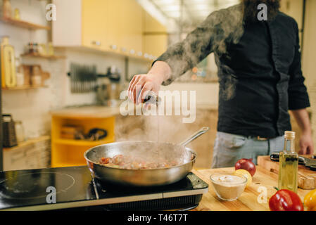 Chef de la viande salée avec vetables dans la poêle Banque D'Images