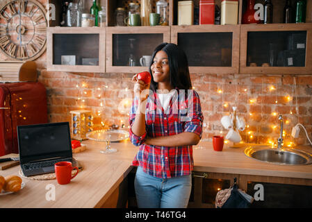 Cheerful black woman cuisson sur la cuisine Banque D'Images