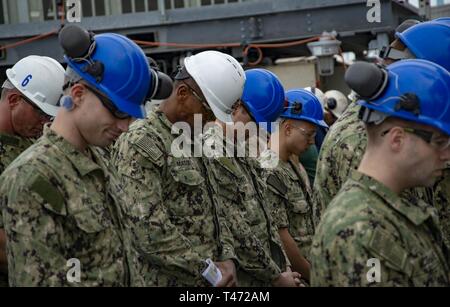 NEWPORT NEWS, Virginie (15 mars 2019) marins affectés à la classe Nimitz porte-avions USS George Washington (CVN 73) baissent la tête pour l'appel au cours d'une cérémonie tenue à pas de mât sur le pont d'envol du navire. George Washington est en cours de révision (complexe de ravitaillement RCOH) au chantier naval Newport News. RCOH est un projet de quatre ans presque réalisée qu'une seule fois pendant une durée de 50 ans du transporteur qui comprend la durée de vie de l'équipage du navire de ravitaillement deux réacteurs nucléaires, ainsi que d'importantes réparations, mises à niveau et de modernisation. Banque D'Images