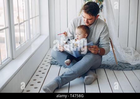 Père assis à la maison avec peu de fils Banque D'Images