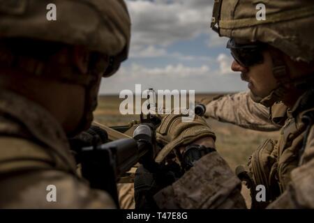 Corps des Marines des États-Unis Le Cpl. Jacob Rodriquez, gauche, un mitrailleur, et Sgt. Austin Sorensen, un anti-tank missileman, tant avec des armes Company, 3e Bataillon, 4e Marines, attaché à but spécial Maritime Aérien Au sol crise Response-Central Task Force, régler la commande choix sur un M240B machine gun au cours de vivre-le-feu de plage de distance inconnue en Asie du Sud-Ouest, le 17 mars 2019. SPMAGTF-CR-CC est spécifiquement conçu pour être capable de déployer l'aviation, la masse, et de la logistique des forces armées de l'avant à quelques minutes d'avis, et prend en charge le fonctionnement de travail, résoudre inhérent par, avec et par les forces des partenaires pour Banque D'Images