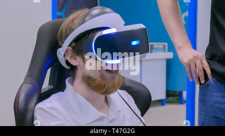 Jeune homme souriant et à l'aide de casque de réalité virtuelle Banque D'Images