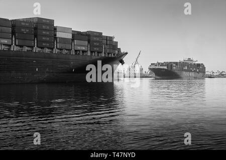 Photo en noir et blanc de deux porte-conteneurs géants se croisant dans l'étroit canal principal de Los Angeles au port de Los Angeles, Californie, États-Unis Banque D'Images