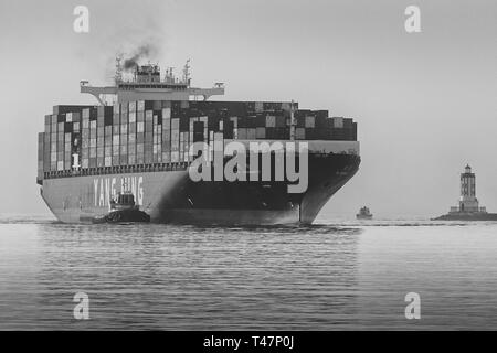 Photo en noir et blanc du navire porte-conteneurs YANG MING, YM UNANIMITÉ, entrant dans le canal principal de Los Angeles, le phare Angels Gate à droite. Banque D'Images