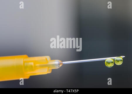 Photo macro d'une seringue avec aiguille gouttes de médicaments Banque D'Images