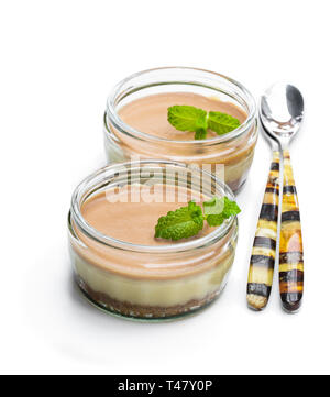 Mini cheesecakes au caramel dans un pot de verre isolé sur fond blanc Banque D'Images