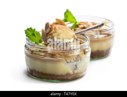 Mini cheesecakes au caramel dans un pot de verre isolé sur fond blanc Banque D'Images