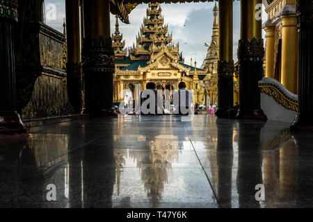 Yangon, Myanmar - 19 septembre 2016 : deux hommes assis à l'entrée du hall à l'intérieur de la pagode Shwedagon complex Banque D'Images