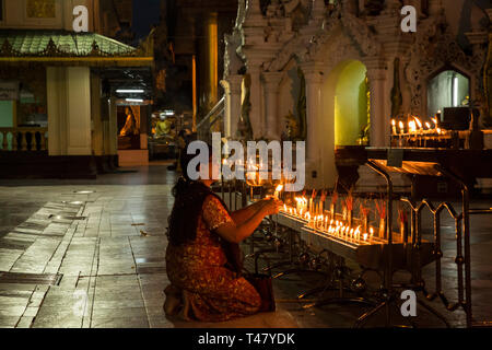 Yangon, Myanmar - 19 septembre 2016 : femme allumant des bougies au complexe de la pagode Shwedagon Banque D'Images