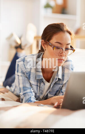Asian Woman Relaxing on Bed Banque D'Images