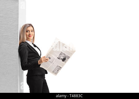 Femme élégante avec un journal leaning against wall isolé sur fond blanc Banque D'Images