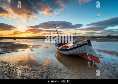 Magnifique coucher de soleil sur un bateau de pêche à Burnham Overy Staithe sur la côte de Norfolk Banque D'Images