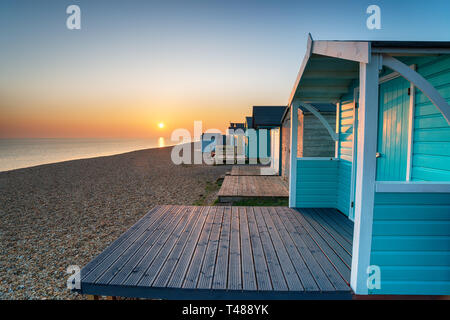 Cabines de plage au coucher du soleil à Milford on Sea dans le Hampshire Banque D'Images