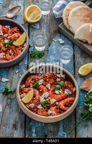 Crevettes saganaki de feta sur une plaque sur une table Banque D'Images