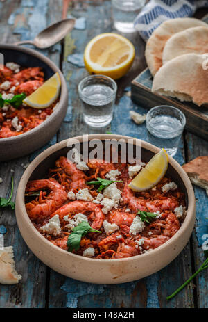 Crevettes saganaki de feta sur une plaque sur une table Banque D'Images