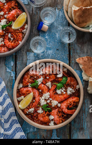 Crevettes saganaki de feta sur une plaque sur une table Banque D'Images