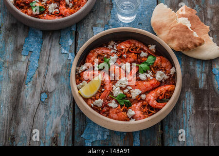 Crevettes saganaki de feta sur une plaque sur une table. Banque D'Images