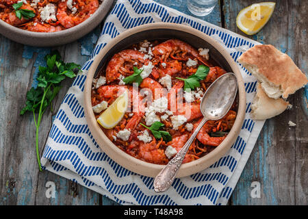 Crevettes saganaki de feta sur une plaque sur une table Banque D'Images