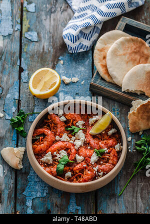 Crevettes saganaki de feta sur une plaque sur une table. Banque D'Images