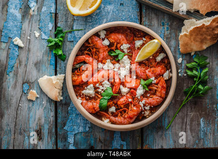 Crevettes saganaki de feta sur une plaque sur une table Banque D'Images