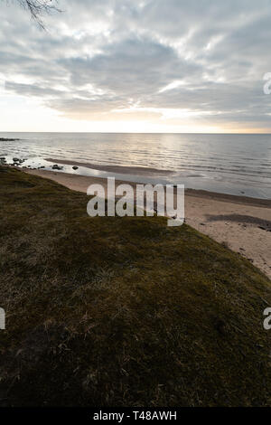 Sable Moss et ciel nuageux sur la plage sur la mer Baltique - Veczemju Klintis, Lettonie - Avril 13, 2019 Banque D'Images