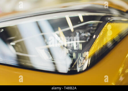 Série d'esthétique automobile : Nettoyer les phares de voiture sport jaune. Banque D'Images