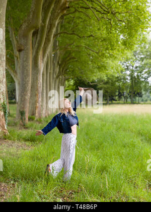 Très belle jeune femme blonde danser dans la campagne en été Banque D'Images