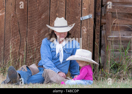 American Girls reposant contre grange dans Wyoming Banque D'Images