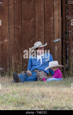 American Girls reposant contre grange dans Wyoming Banque D'Images