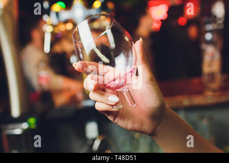 Un verre cassé avec main de femme vin close up. Banque D'Images