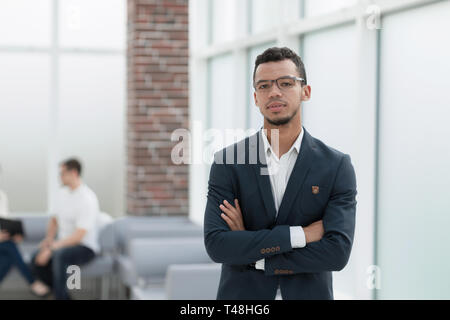 Jeune homme d'affaires sur l'arrière-plan d'un bureau moderne. photo with copy space Banque D'Images