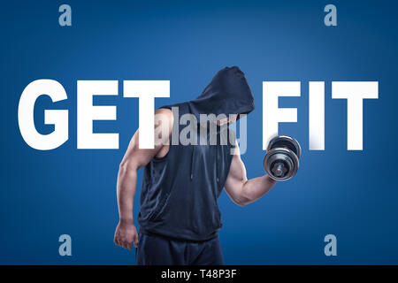 L'homme athlétique en sleeveless hoody posant avec demi-tour dumbell dans une main sur fond bleu avec titre de SE METTRE EN FORME. Banque D'Images