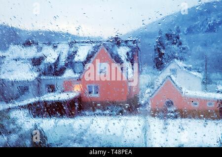 Gouttes de pluie sur un carreau de fenêtre, vue brouillée d'une maison en hiver, Witten, Rhénanie du Nord-Westphalie, Allemagne Banque D'Images