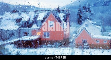 Gouttes de pluie sur un carreau de fenêtre, vue brouillée d'une maison en hiver, Witten, Rhénanie du Nord-Westphalie, Allemagne Banque D'Images