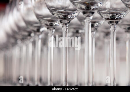 De nombreux verres à vin cristal transparent stand dans la rangée sur l'étagère en bois brun du rack. Vue de côté. Le concept de la dégustation de whisky, le brandy, le port Banque D'Images