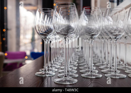 De nombreux verres à vin cristal transparent stand dans la rangée sur l'étagère en bois brun du rack. Vue de côté. Le concept de la dégustation de whisky, le brandy, le port Banque D'Images