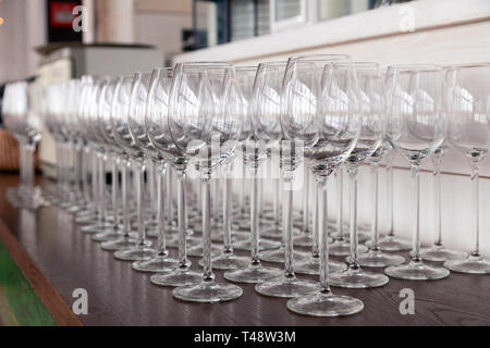 De nombreux verres à vin cristal transparent stand dans la rangée sur l'étagère en bois brun du rack. Vue de côté. Le concept de la dégustation de whisky, le brandy, le port Banque D'Images