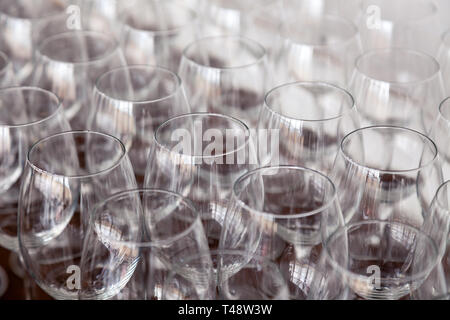 De nombreux verres à vin cristal transparent stand dans la rangée sur l'étagère en bois brun du rack. Vue de côté. Le concept de la dégustation de whisky, le brandy, le port Banque D'Images